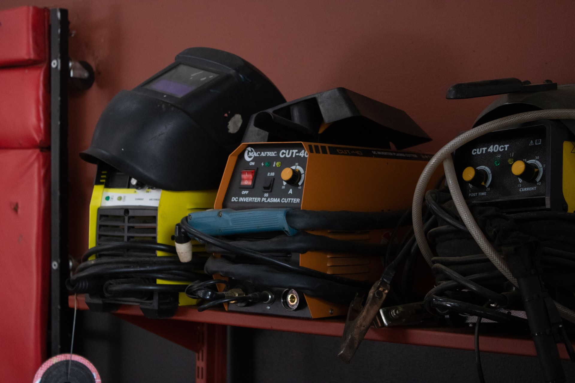 Welding helmet, MMA welder and plasma cutter on the workbench